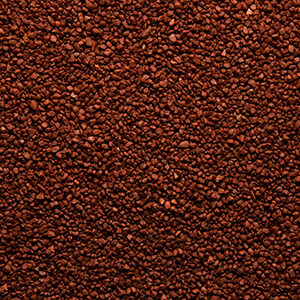 Nærbillede af rød farvet sand 1,2-1,8 mm der anvendes til stentæppe, fugefri gulve, slidstærke gulve og skridsikre gulve på industrigulv, butiksgulv, showroomgulv, værkstedsgulv, kontorgulv, køkkengulv og vådrumsgulv og leveres af ekspert i og leverandør af materialer til gulve Stonewalk
